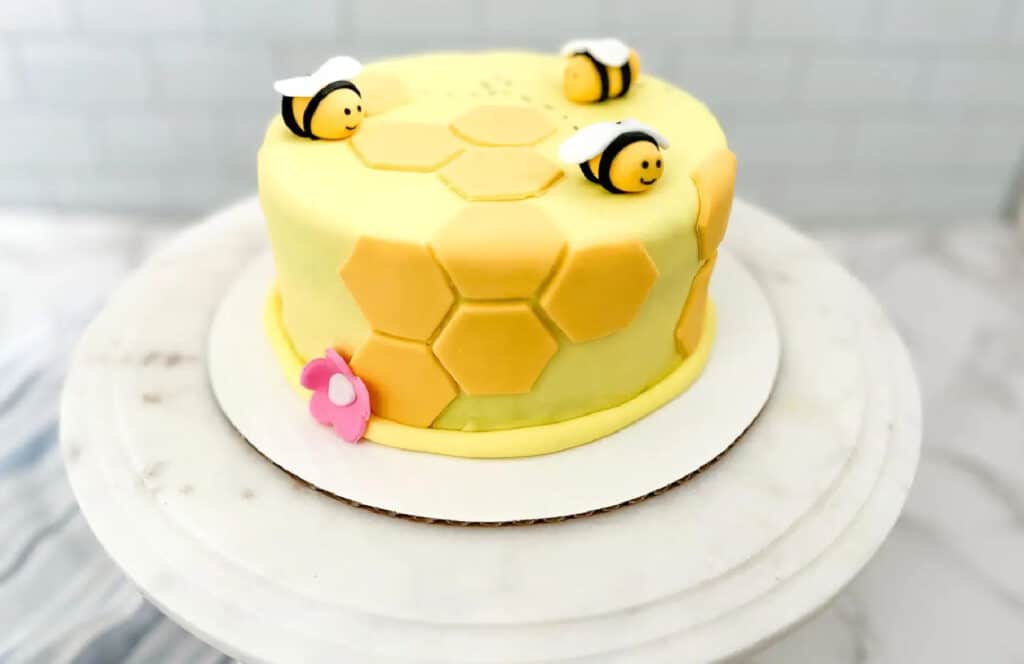 A round bee themed two layer cake cake.