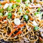 beef yakisoba noodles on a black plate.