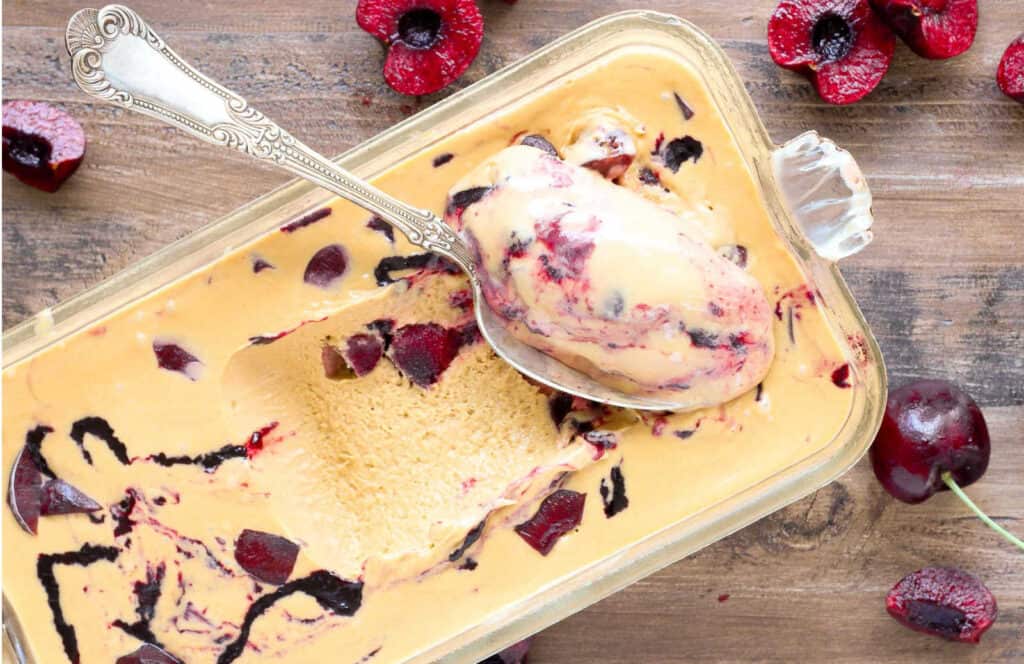 A glass dish with cherry bourbon ice cream.