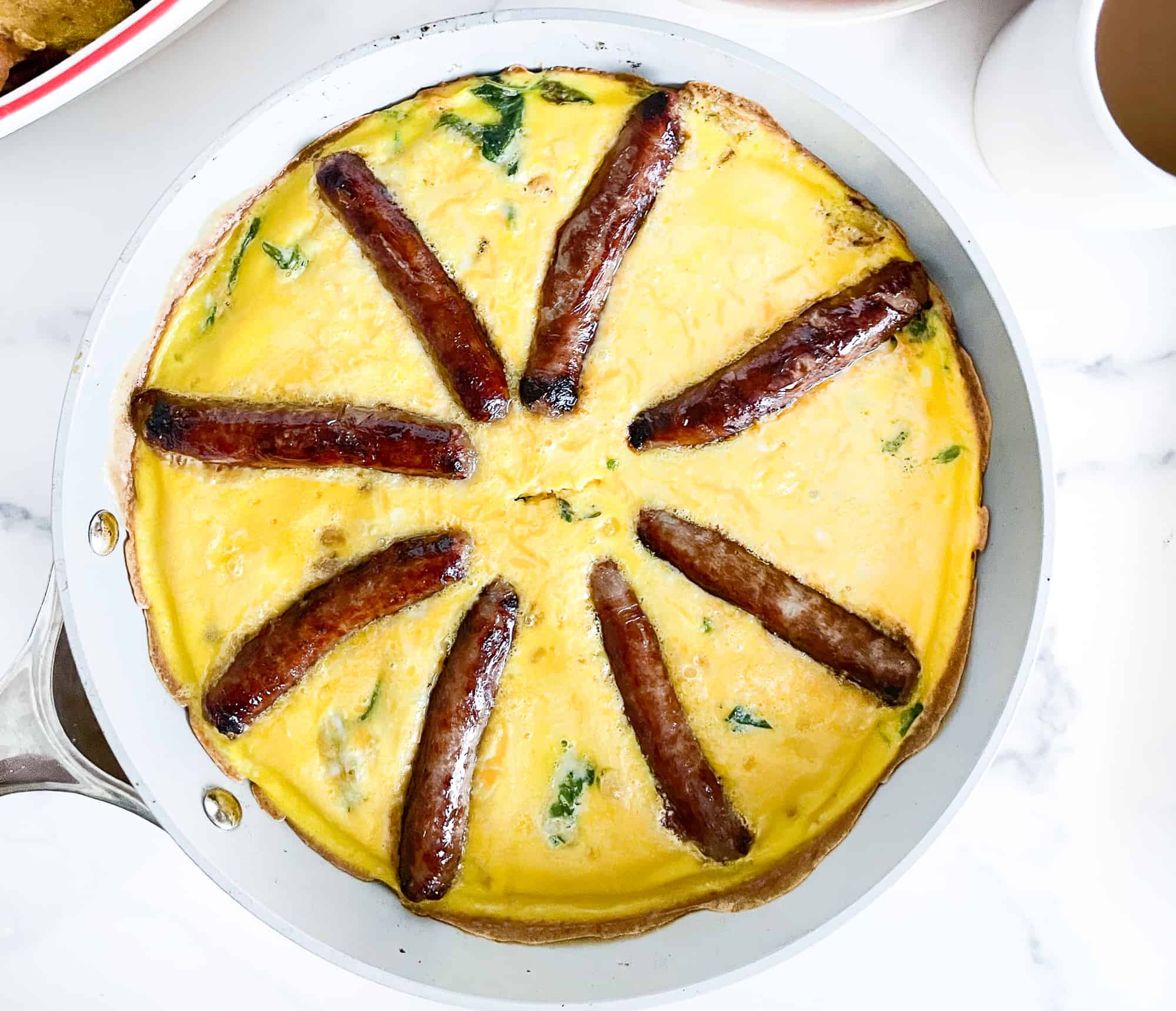 Eggs and sausage in a frying pan.