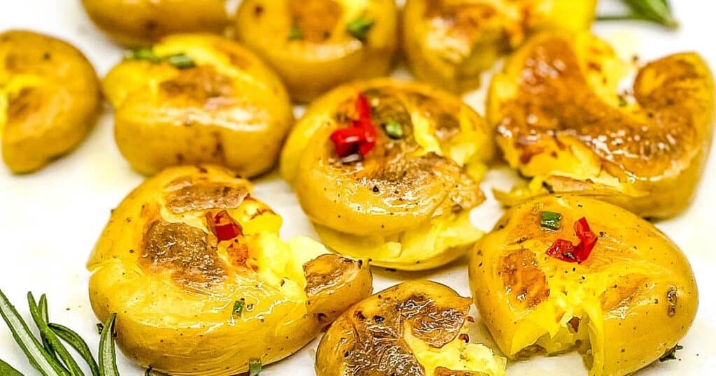 Smashed, fried Calabrian potatoes on a white plate.