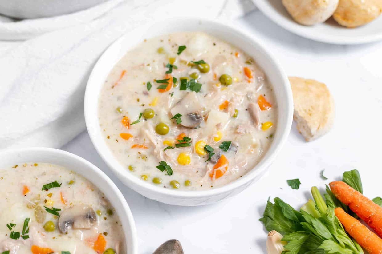 A large bowl of chicken pot pie soup full of chicken and vegetables. 