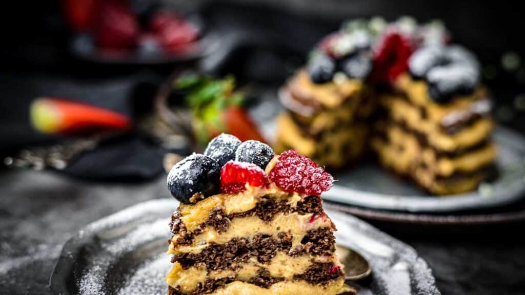Chocolate Chaffle Cake on a plate with whole cake in the background. 