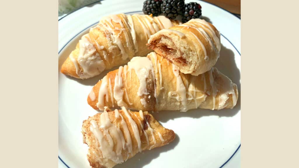 Cinnamon crescent rolls on a white plate.