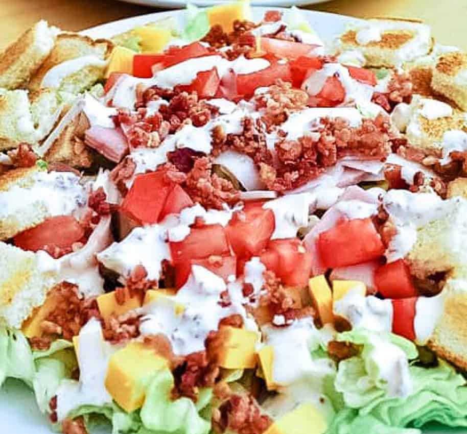 Club Sandwich Salad with tomatoes, cheese, bacon, and dressing. 