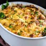 Chicken casserole with baked cheese inside a white dish.