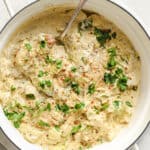 Creamy chicken thighs with artichoke hearts in a pan.