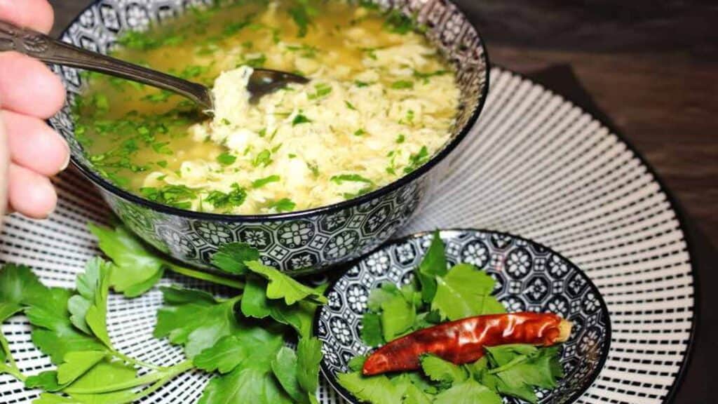 Egg Drop Soup inside blue bowl with spoon.