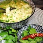 Egg Drop Soup inside blue bowl with spoon.