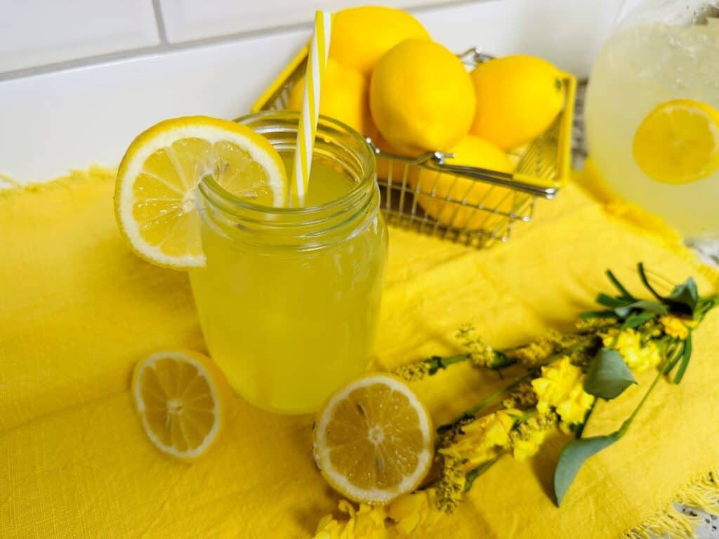 Fresh squeezed lemonade with straw in mason jar.