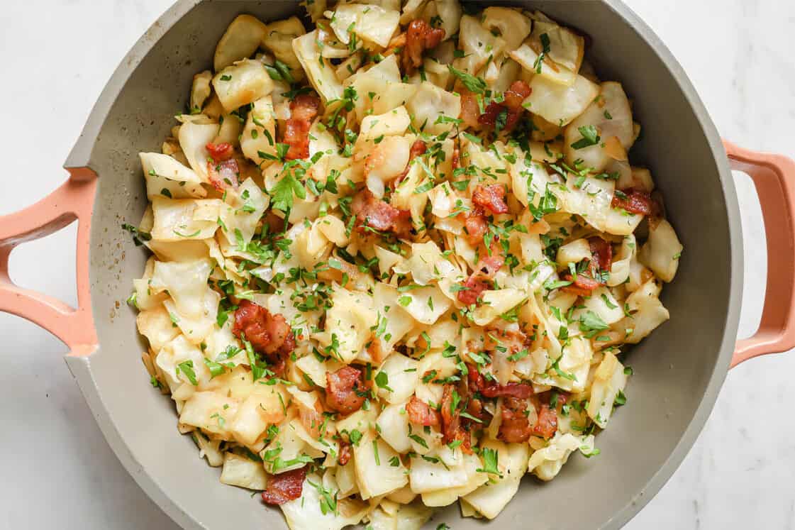 A pan filled with crispy potatoes and sizzling bacon.