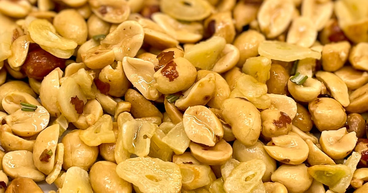 Close-up shot of garlic peanuts with chopped rosemary.