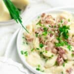 Gnocchi with Bacon and Cream Sauce served on a white plate.