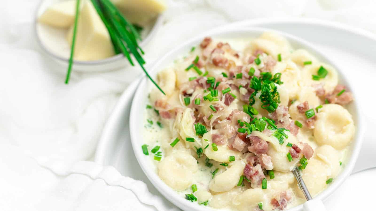 Gnocchi with Bacon and Cream Sauce served on a white plate.