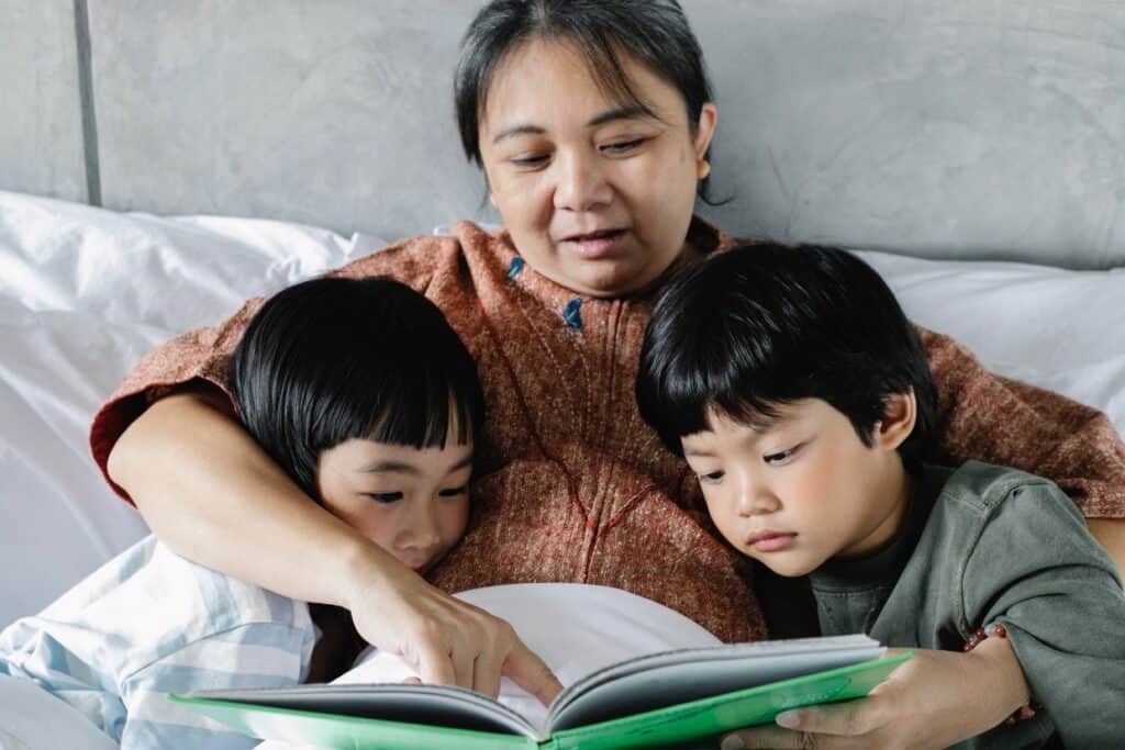 Grandma reading bedtime stories to two grandkids