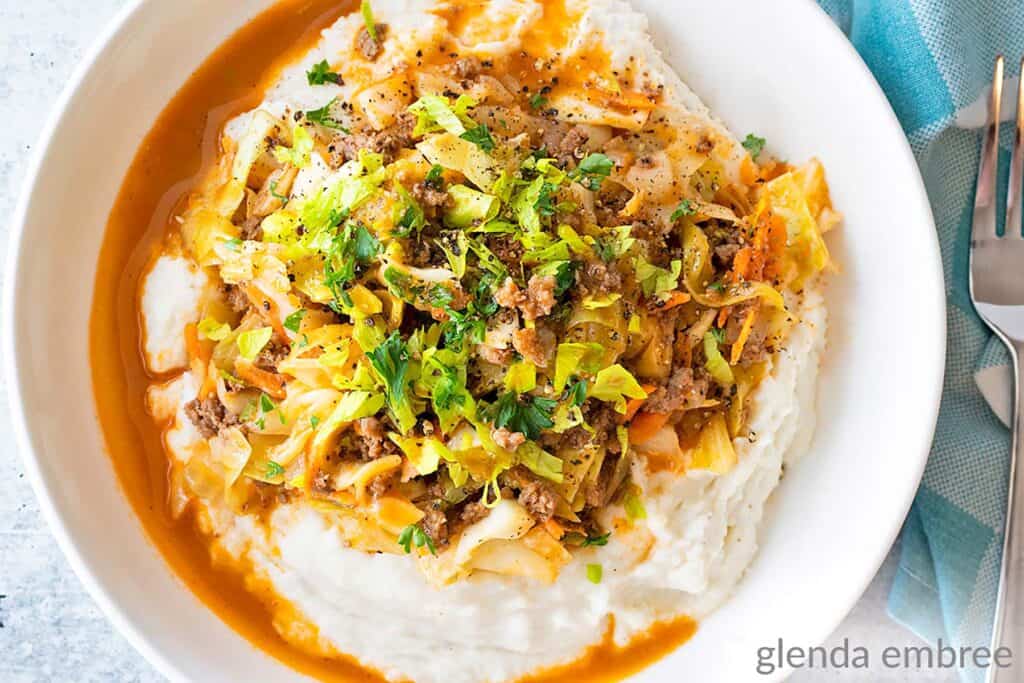 Ground Beef and Cabbage over Mashed Potatoes in a white bowl.