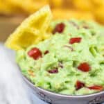 Guacamole Dip with Sour Cream in a bowsl with chips.