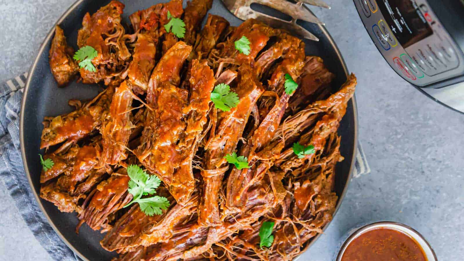 Instant Pot BBQ beef brisket shredded on a plate.