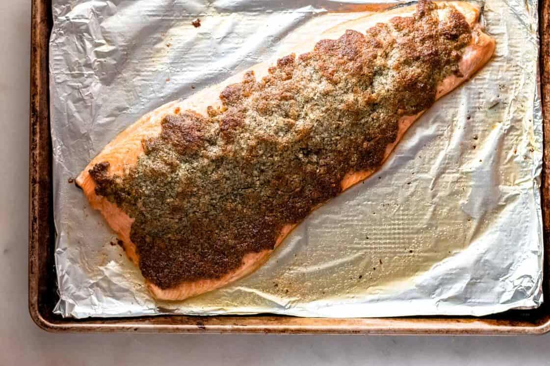 Keto baked parmesan salmon on foil on a baking sheet.