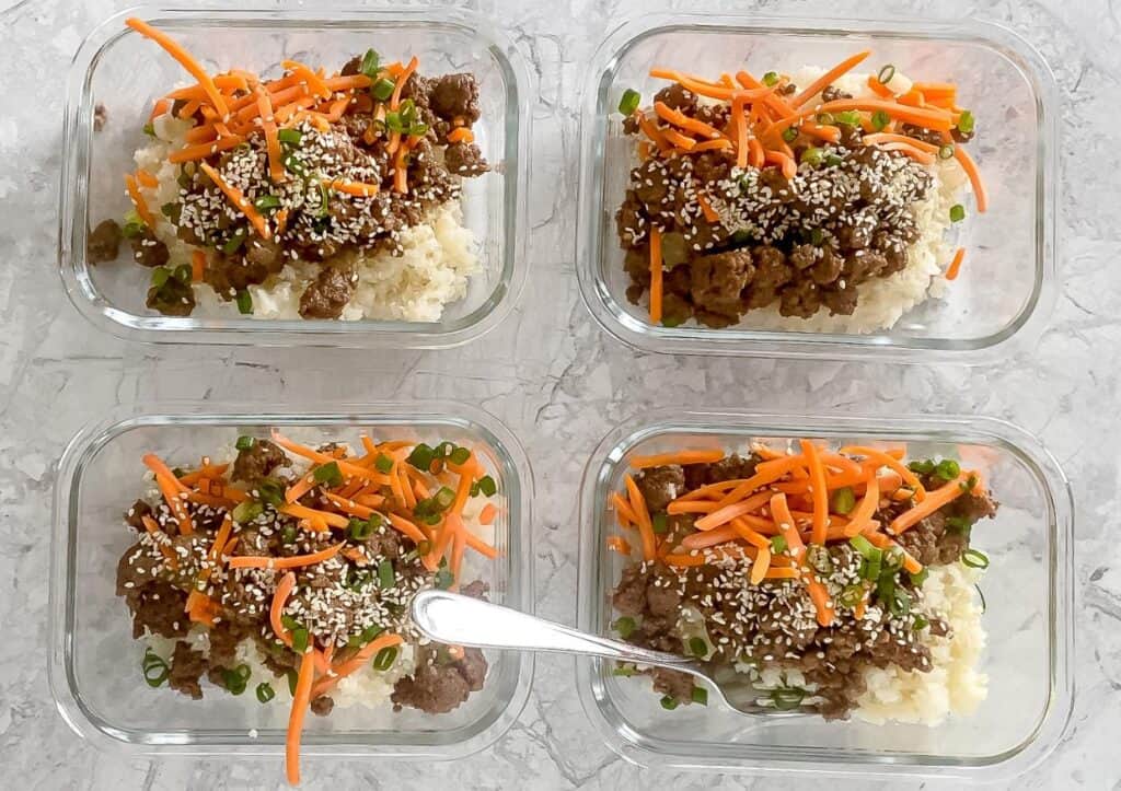 Four glass containers of Korean ground beef meal prep bowls.