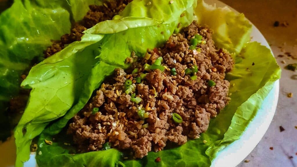 Korean Ground Beef in lettuce wrap on white plate