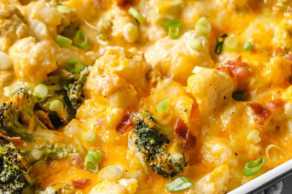 Loaded broccoli cauliflower casserole in a baking dish garnished with green onions.