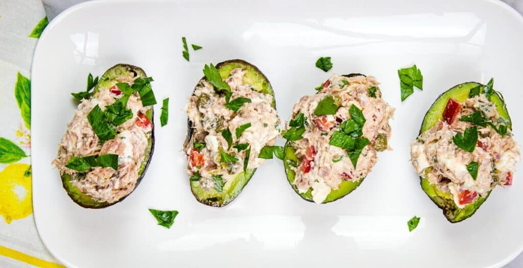 Mediterranean Tuna Salad in avocado boats on a platter.