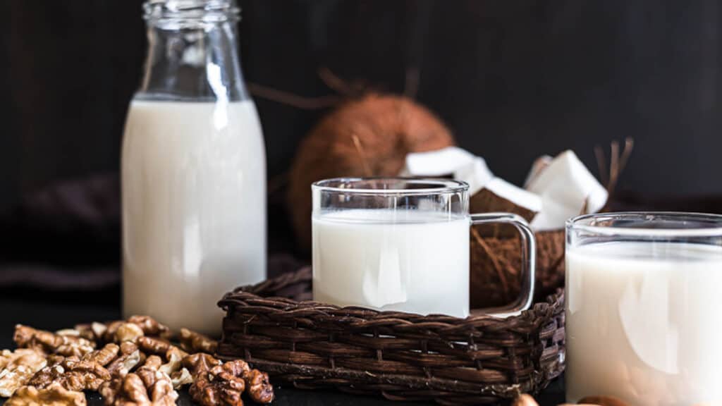 Types of nut milk in glasses and a jar. 