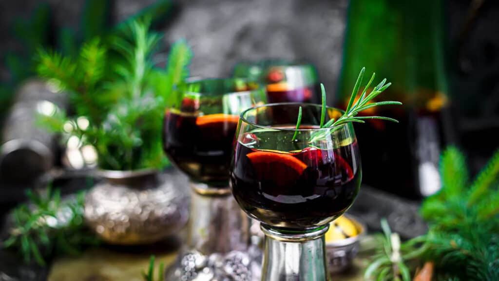 Mulled Wine inside wine glasses with fresh rosemary. 
