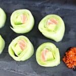 Cucumber Rolls on a black board.