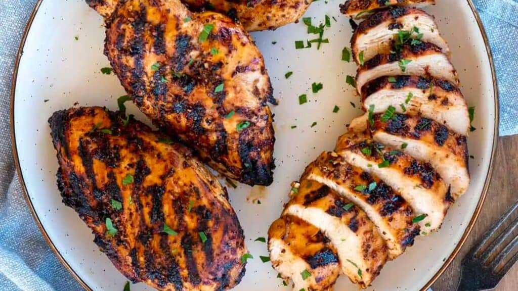 sliced grilled chicken breasts on plate.