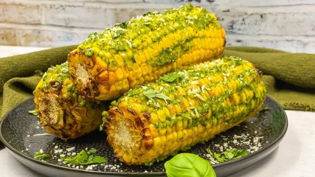 Pesto corn on the cob on a serving plate. 