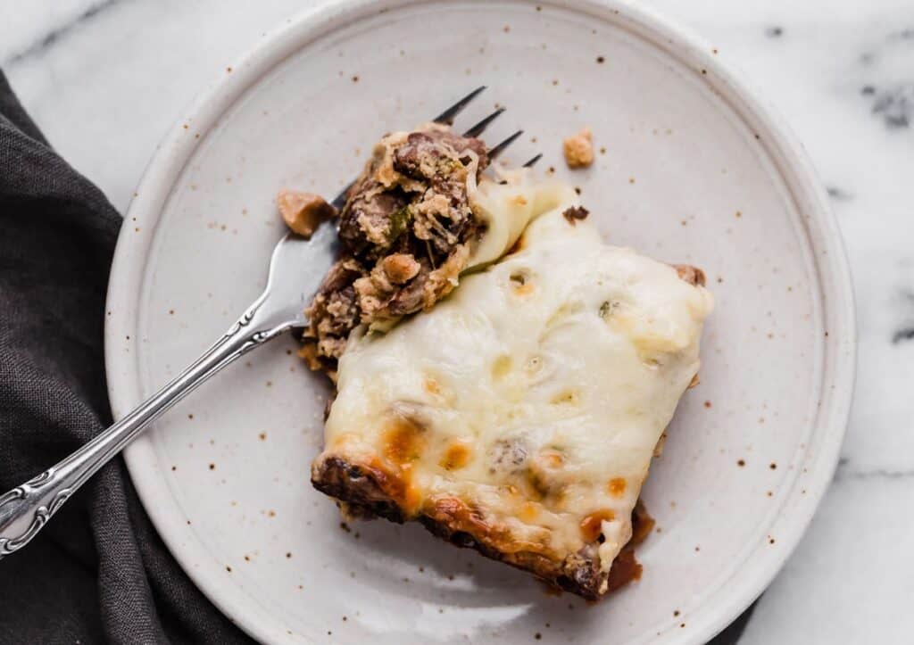 Philly cheesesteak casserole on a plate with a fork.