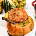 Creamy Roasted Pumpkin Soup inside baked pumpkin bowl.