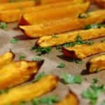 Pumpkin Fries on a parchment paper with herbs.