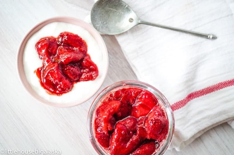 A jar of berries and yogurt.