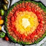 Rainbow Pizza filled with colorful tomatoes and green fresh chives around it.