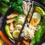 Low Carb Ramen Chicken Noodles in a black bowl with various vegetables and boiled egg.