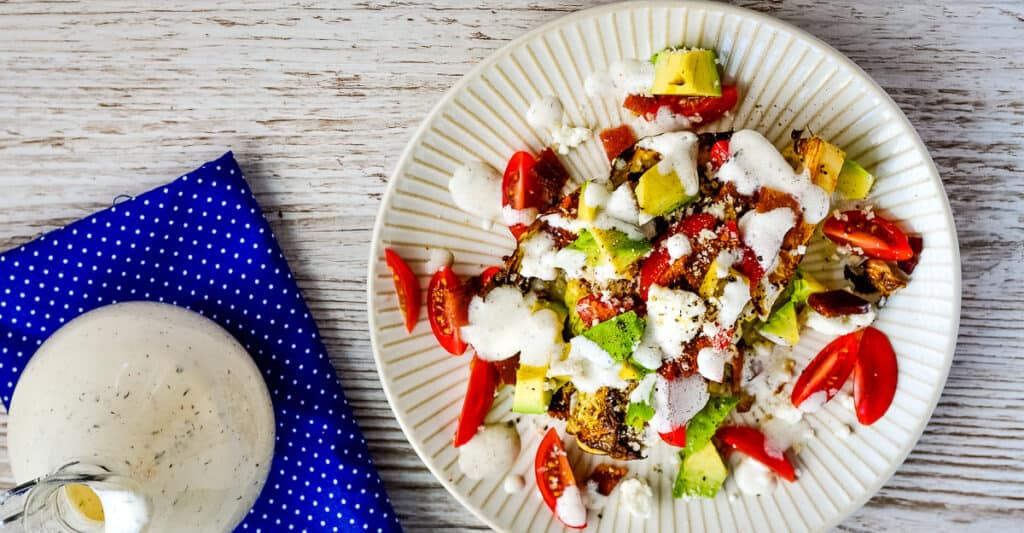 Roasted cabbage steak topped with tomatoes, bacon, goat cheese, and more.