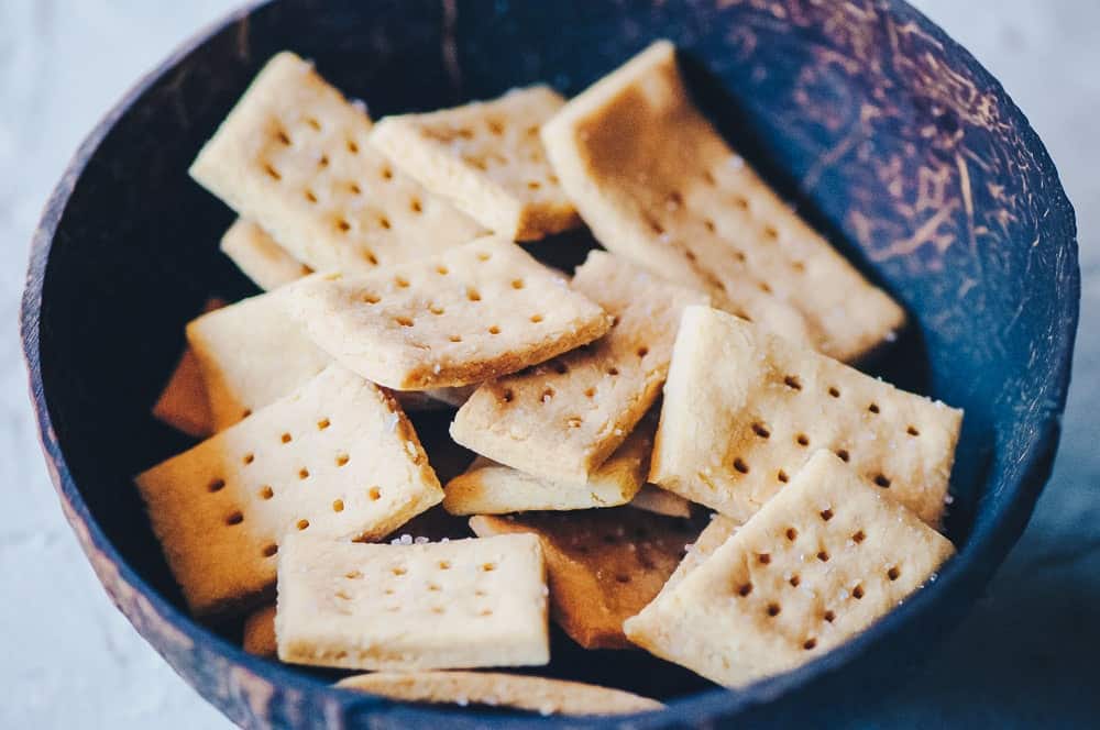A small brown bowl filled with tan crackers.
