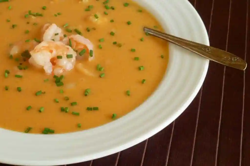 A bowl of shrimp bisque garnished with chives.
