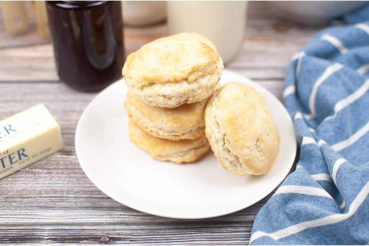 Sourdough Discard Biscuits stacked on plate with blue cloth napkin.