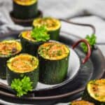 Stuffed Zucchini Mini Bites on a plate with herbs.