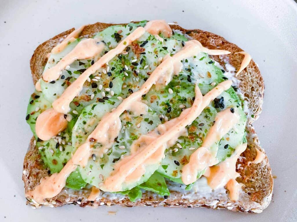 Sushi Toast with avocado, cucumbers, spicy mayo, cream cheese and furikake on toast on a white background.