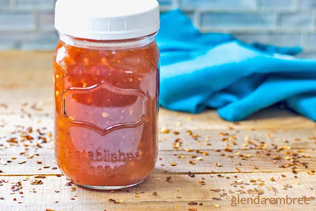 Sweet Chili Sauce in a mason jar on a wooden table.