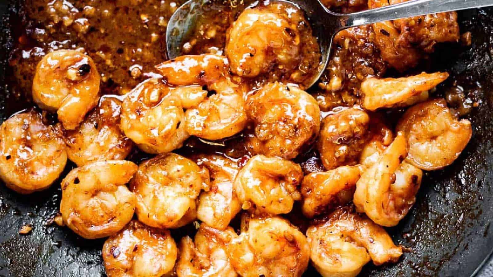 Szechuan Shrimp in a pan with a serving spoon.