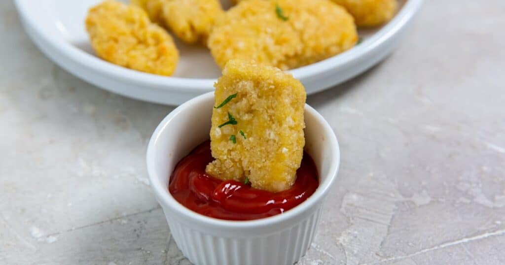 Trader Joe's Chicken Nuggets being dipped into ketchup.