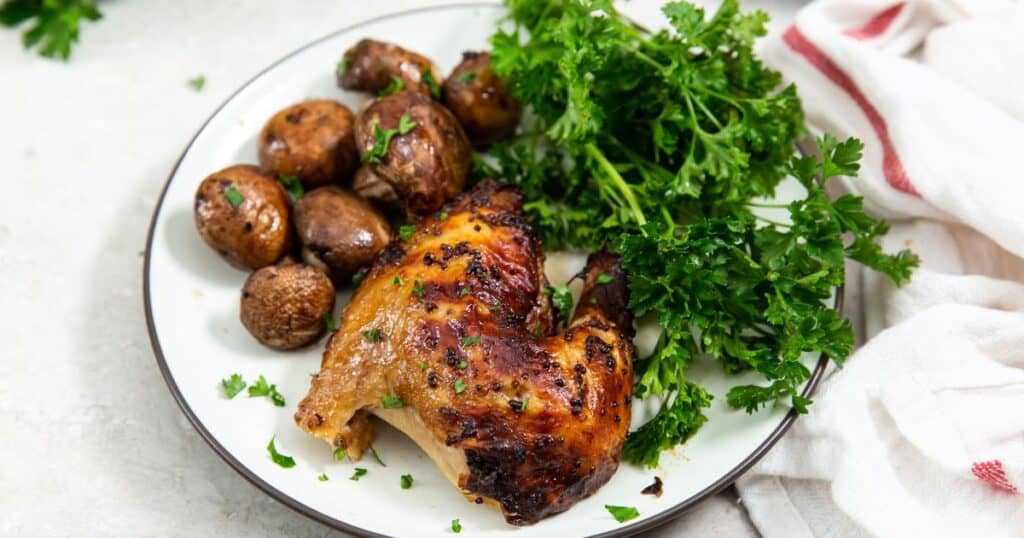 Trader Joe's spatchcock chicken on a plate with mushrooms and parsley