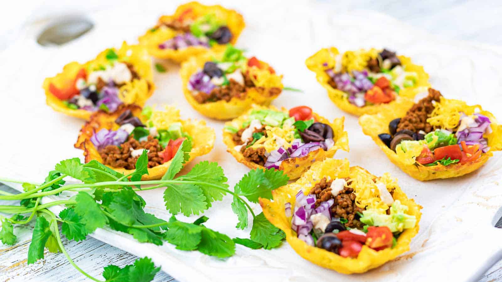 Easy Crunchy Taco Cups on a white board with cilantro. 