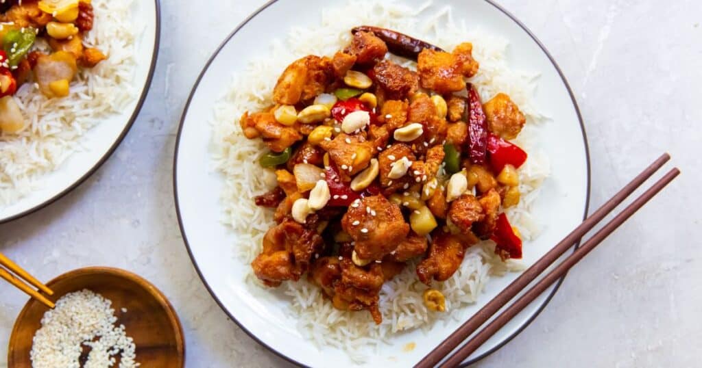 Trader Joe's Kung Pot Chicken on a plate with rice and chop sticks.